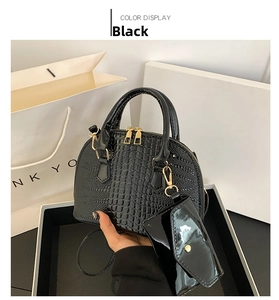Close-up of black crocodile pattern shell bag with glossy finish and matching small coin purse