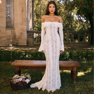 Detail of elegant white lace off-shoulder dress with trumpet sleeves and fishtail hem