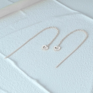 Detailed view of S925 sterling silver heart-shaped long chain tassel earrings on white texture
