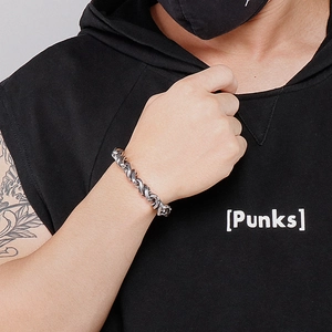 Détail macro d'un bracelet corde épais en acier inoxydable pour homme sur le poignet