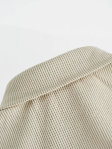 Detail of a beige corduroy jacket collar with premium stitching and ribbed texture