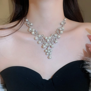 Close-up of elegant Y-shaped necklace with pearls and rhinestones on a female model