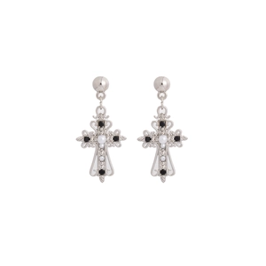 Détail de boucles d'oreilles croix évidées avec strass noirs et perles blanches