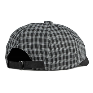 Gros plan sur la sangle réglable et la boucle métallique d'une casquette gavroche à carreaux