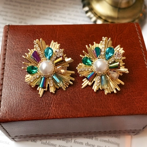 Macro detail of vintage baroque crystal flower earrings with colorful rhinestones and pearls