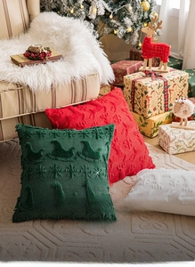 Detail of plush Christmas pillow covers with embroidered reindeer and snowflake patterns