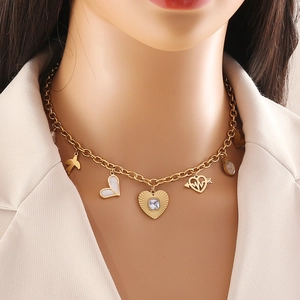 Golden multi-pendant necklace with heart, arrow and key charms on a model