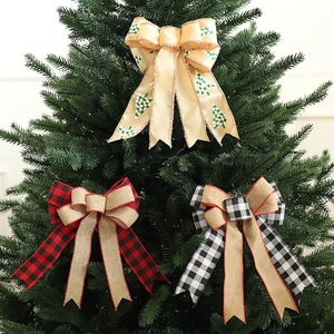 Christmas plaid bows with tree prints hanging on a green Christmas tree for decoration