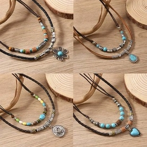 Detail view of multilayered braided leather bracelets with turquoise beads and silver pendants