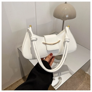 Detail of white crescent shoulder bag with golden buckle and woven leather handle