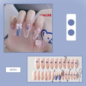 Detailed view of long coffin press-on nails with blue bows and pearl accents