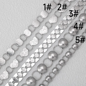 Detailed macro view of five assorted silver stainless steel jewelry chain styles with labels
