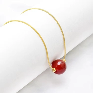 Golden titanium steel snake chain necklace with a vibrant red agate bead pendant