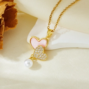 Detail of gold heart necklace with pink enamel, pavé crystals and round white pearl drop