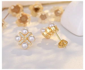 Macro shot of pearl flower earrings with gold base and sparkling zircon accents