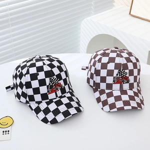 Detail view of racing flag embroidery on checkered pattern baseball caps for kids