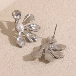 Macro shot of silver textured petal flower earrings with center pearl detailing