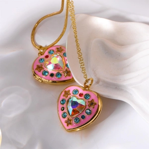 Detailed macro view of heart-shaped gold pendants with pink enamel and colorful crystals