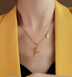 Dettaglio della collana con coniglio dorato e ciondolo Luck indossata da modella