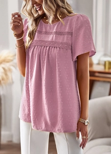 Detailed view of pink short-sleeve blouse featuring lace hollow-out decor and polka dot texture