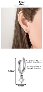 Detail showing a geometric drop earring with a four-prong set round clear stone