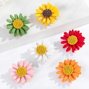 Daisy flower brooches in six vibrant colors including green and yellow on white stands