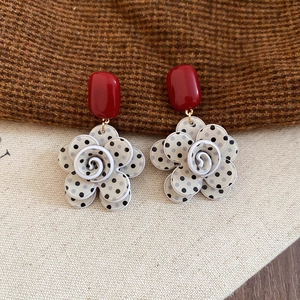 Detail of vintage floral drop earrings with red oval studs and black polka dot petals