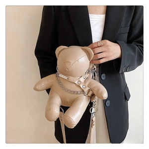 Detail of cute bear-shaped PU leather crossbody bag with silver chain on model