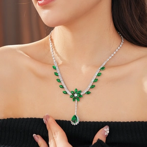 Macro detail of luxury flower necklace with green stones and zircons worn by model