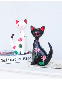 Detail of hand-painted wooden cat figurines with lotus patterns on white background