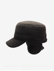 Detail of dark brown wool winter hat with ear flaps and metallic logo accent