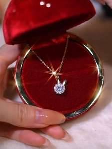 Dettaglio della collana con ciondolo a coniglio dorato e cristallo in scatola di velluto