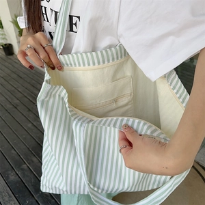 Detail of striped canvas tote bag showing interior zipper pocket and spacious main compartment