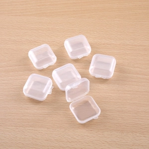 Clear plastic storage boxes set for jewelry and small items on a wooden surface