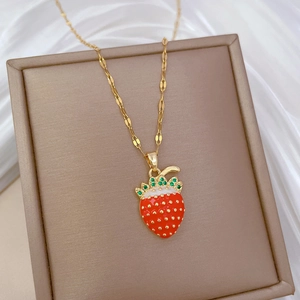 Macro view of crystal strawberry pendant with green zircon leaves on gold titanium chain