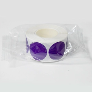 Close-up of a roll of purple round self-adhesive label stickers in a clear plastic bag