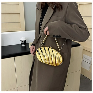 Detailed view of leaf-shaped acrylic evening bag with gold beaded handle and metal strap