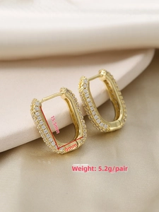 Macro detail of U-shaped gold earrings with zircon pavé weighing 5.2g and 15.5mm height