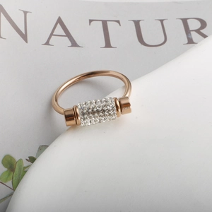 Close-up of golden rotating ring featuring a crystal-encrusted cylinder pendant
