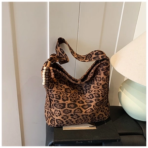 Detail of leopard print hobo bag featuring vintage wood bead tassel and suede texture