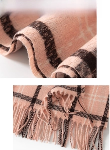 Detail of pink and black plaid scarf fabric with soft cashmere-like texture and tassels