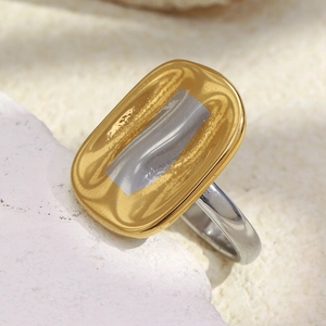 Minimalist two-tone 18K gold plated stainless steel ring on a white stone background