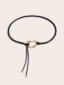 Detail of black leather rope belt with gold molten metal buckle and metallic ends