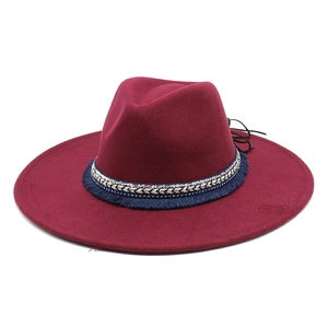 Close-up of burgundy wool felt jazz hat with ethnic pattern ribbon and blue fringe detail