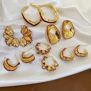 French retro gold earring set with pearls and red lacquer on white silk background