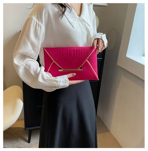 Vue détaillée de la pochette enveloppe rose rouge avec motif crocodile et doré