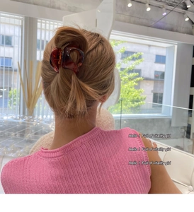 Vue arrière d'une pince à cheveux ambre brillante fixant un chignon sur une femme