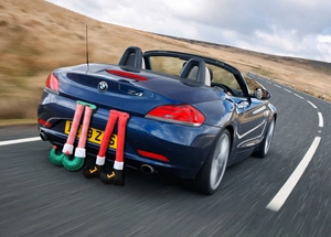 Whimsical elf and Santa legs ornaments attached to car trunk for holiday decor