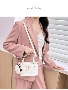 White quilted bucket bag with gold swan detail and mini coin purse on pink suit model