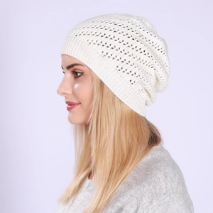 Detail view of the white open-work crochet knit texture on a slouchy beanie for women